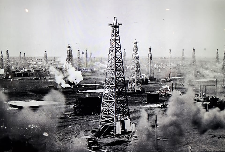 A historic oil field crowded with wooden drilling derricks